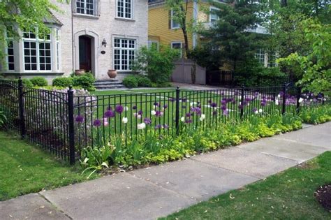 big house with black metal fence|black houses in front of house.